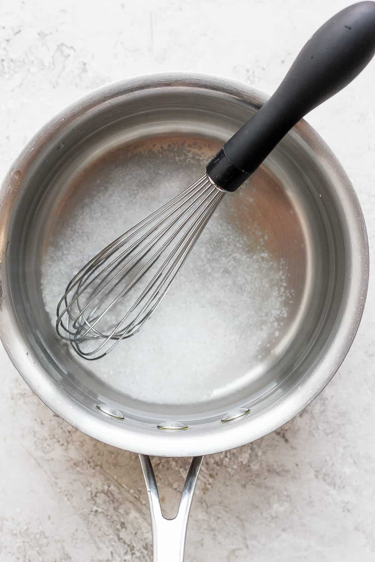 Salt in a pot with a whisk.