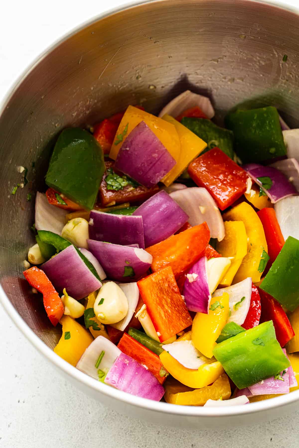 Rainbow veggies marinating in a bowl.