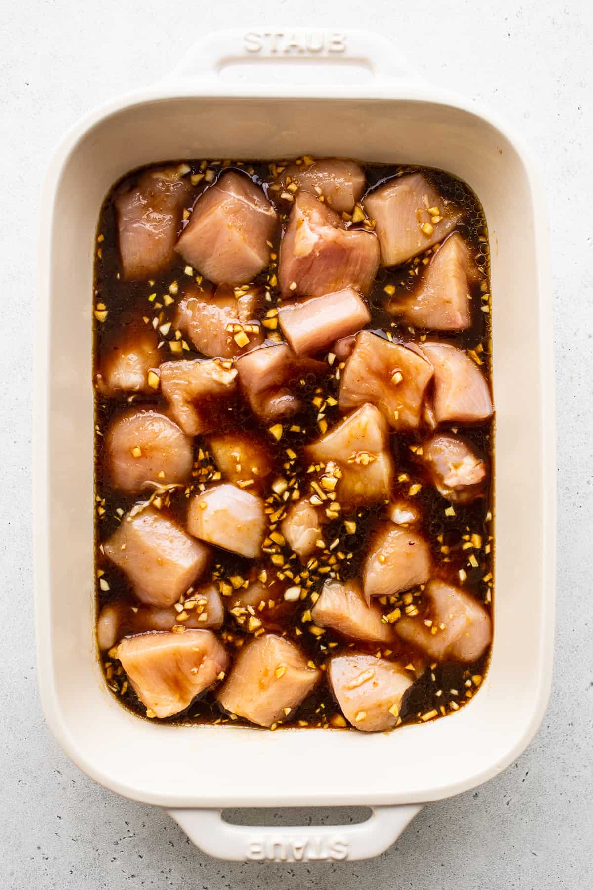 chicken marinading in dish.