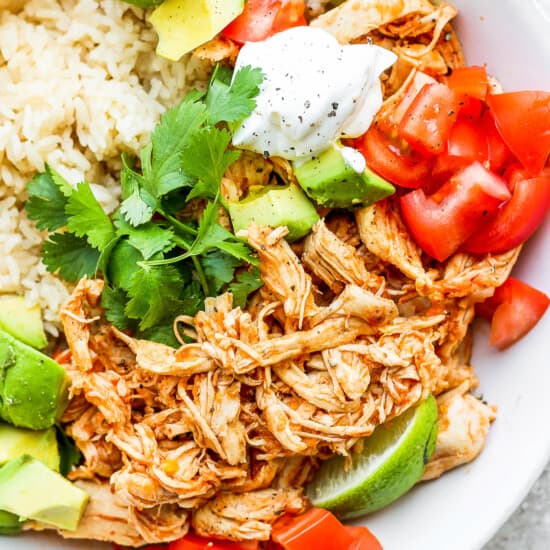 A white bowl with rice and chicken tinga.