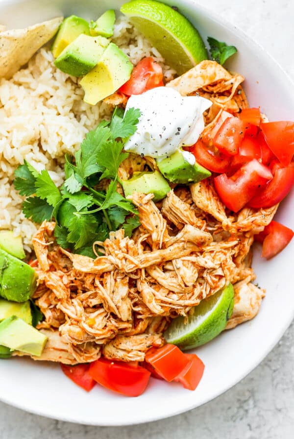 A white bowl with rice and chicken tinga.