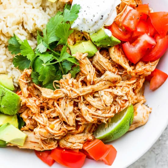 Mexican chicken rice bowl with avocado, tomatoes and sour cream.
