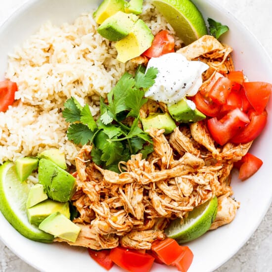 Mexican chicken rice bowl with avocado, tomatoes and rice.