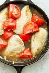 tomatoes and chicken in pan.