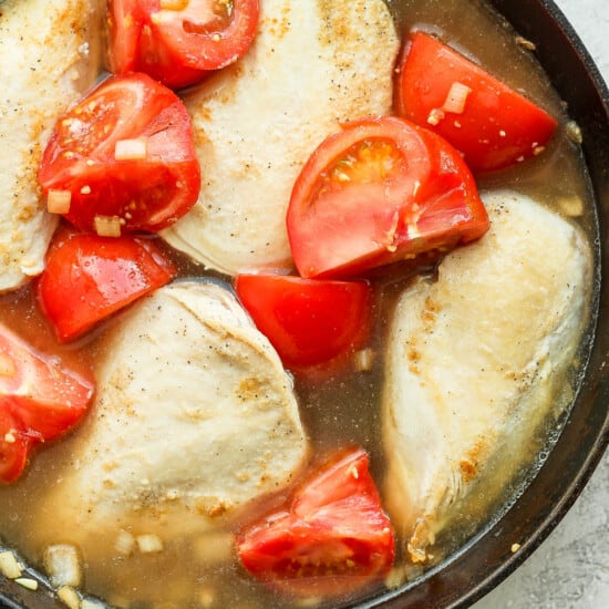 tomatoes and chicken in pan.