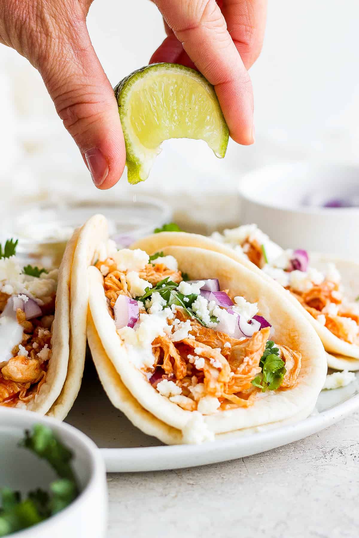 Squeezing fresh lime juice over a chicken tinga taco. 