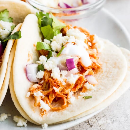 Chicken Tinga Tacos on a plate with toppings.