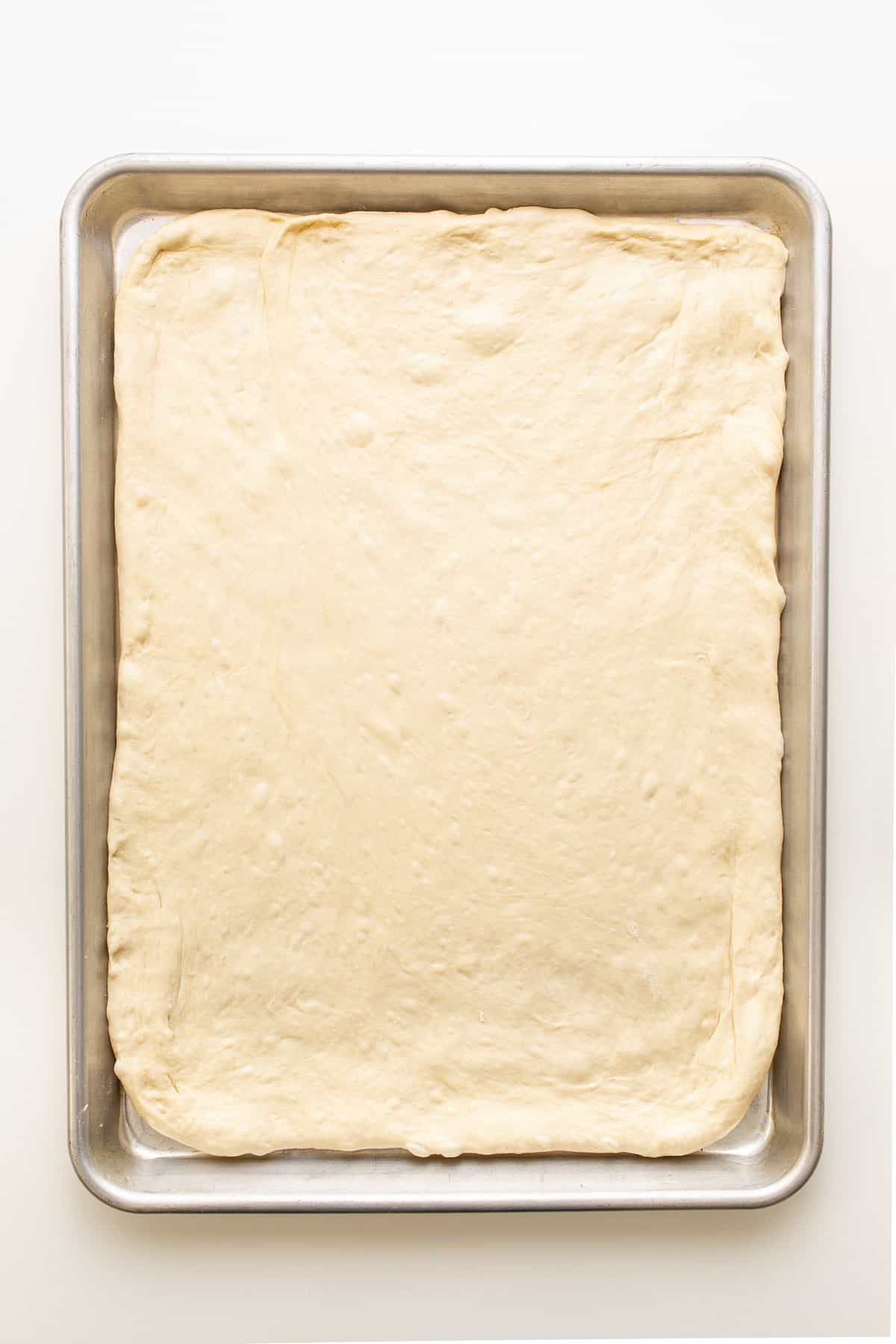 pizza dough on baking sheet