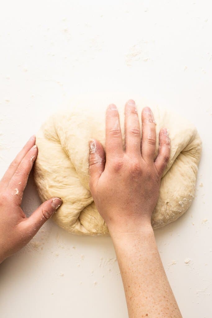 hand kneading dough on surface
