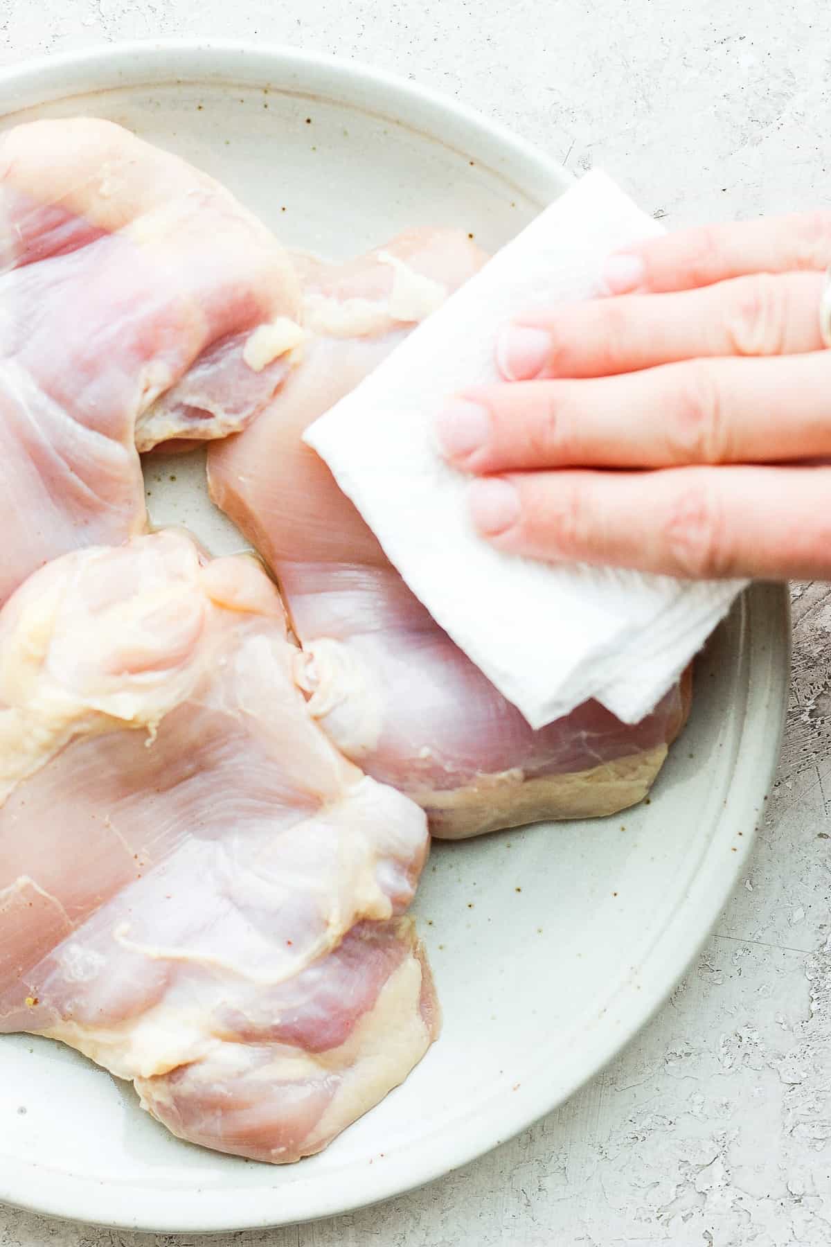 removing moisture from thighs on plate.