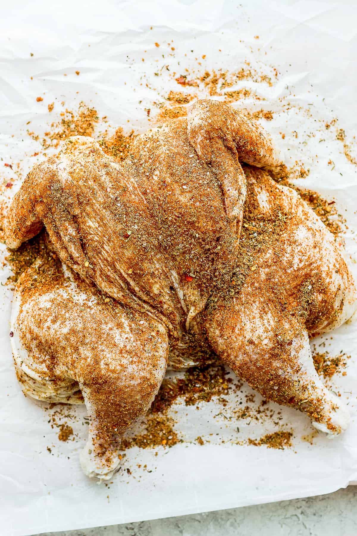 whole chicken rubbed with spices.