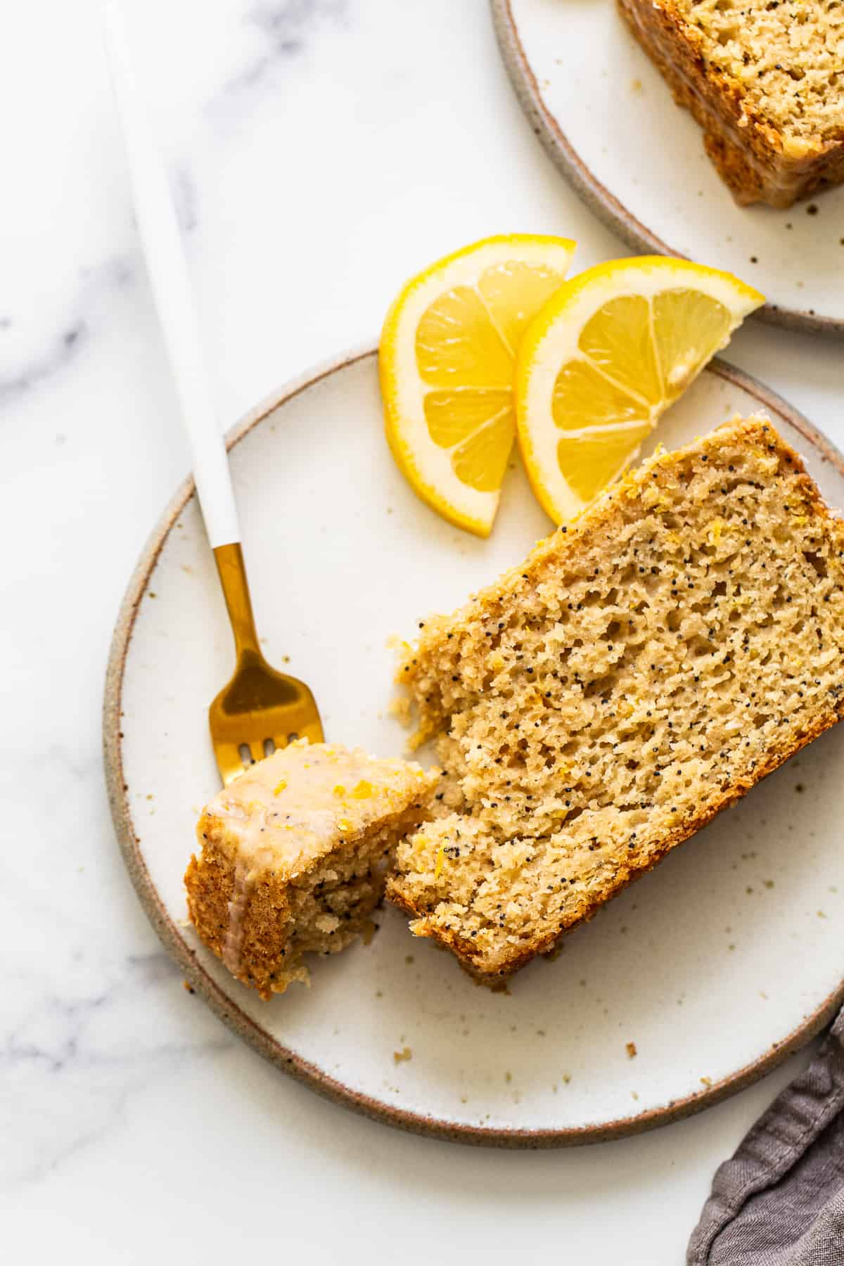 A piece of lemon poppy seed bread on a plate. 