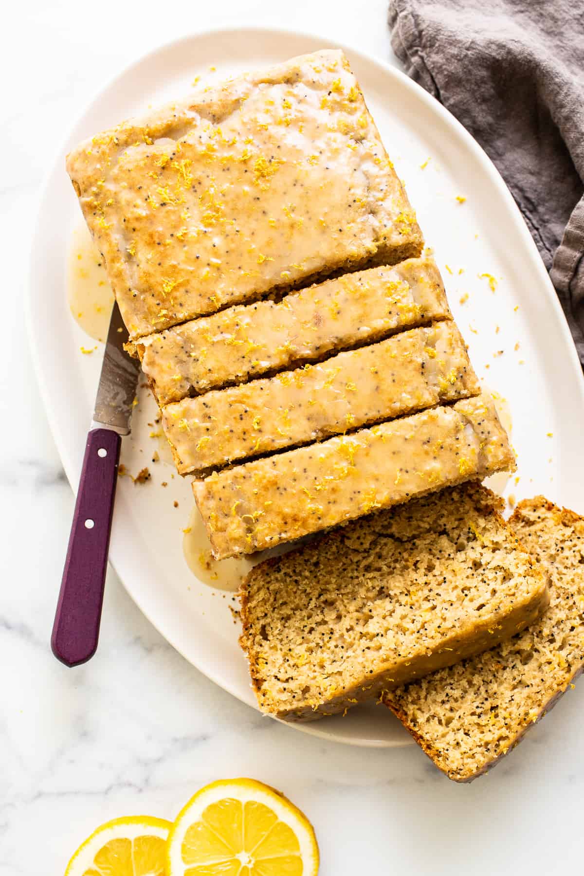 A sliced loaf of lemon poppyseed bread on a plate. 