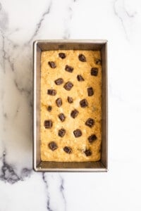 Chocolate chip cookie dough in a baking pan.