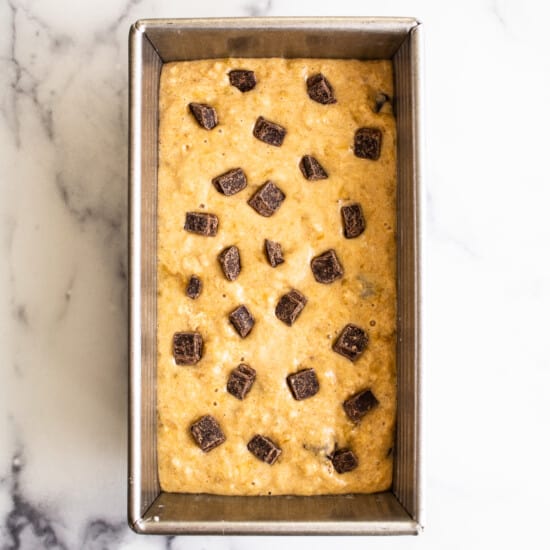 Chocolate chip cookie dough in a baking pan.
