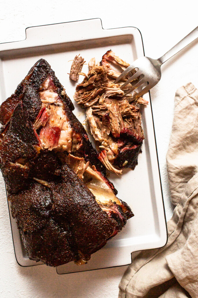 Finished pork shoulder on a tray after resting.