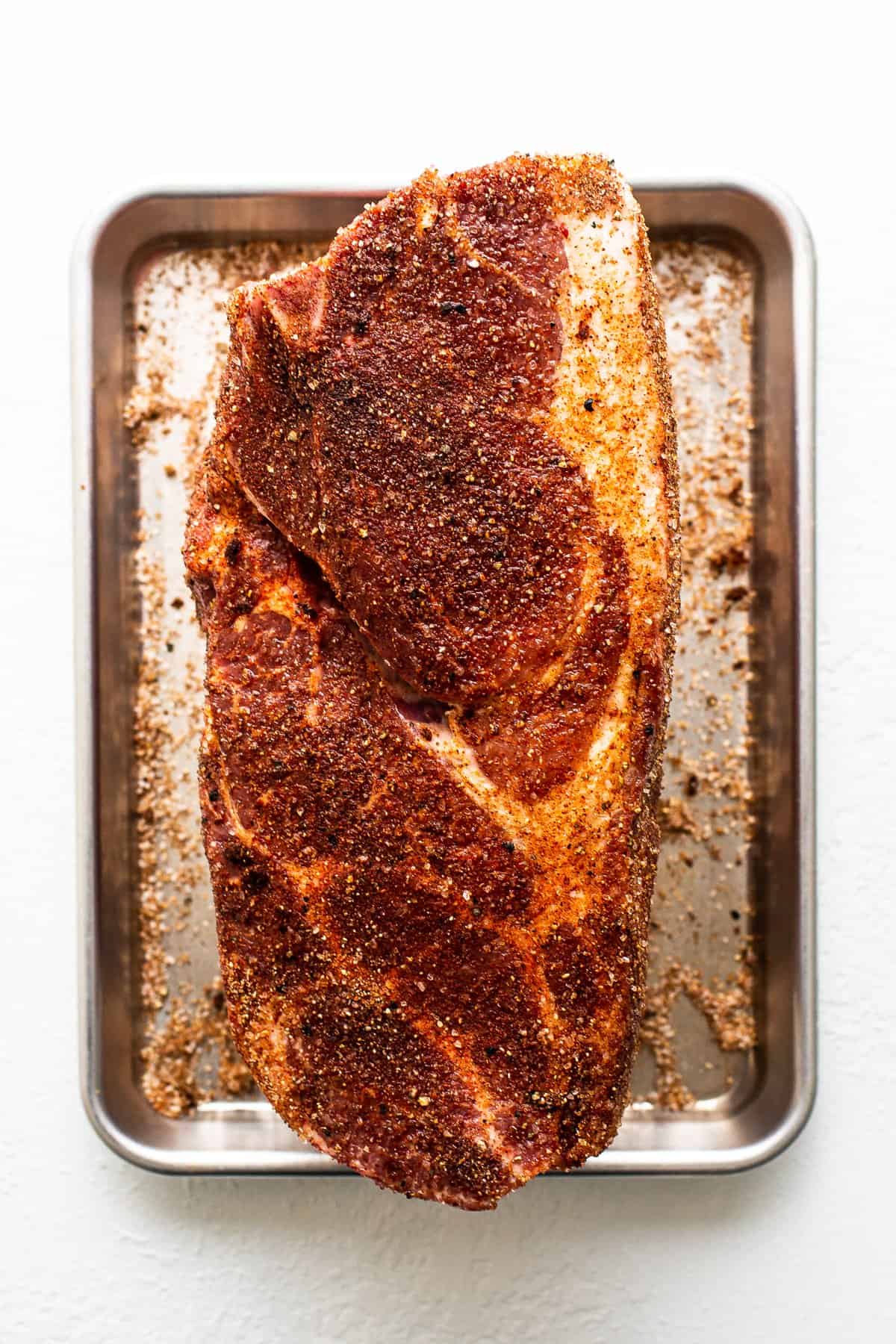 Pork shoulder sprinkled with dry rub.