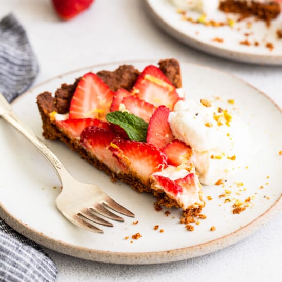 A slice of strawberry pie with whipped cream and a fork.