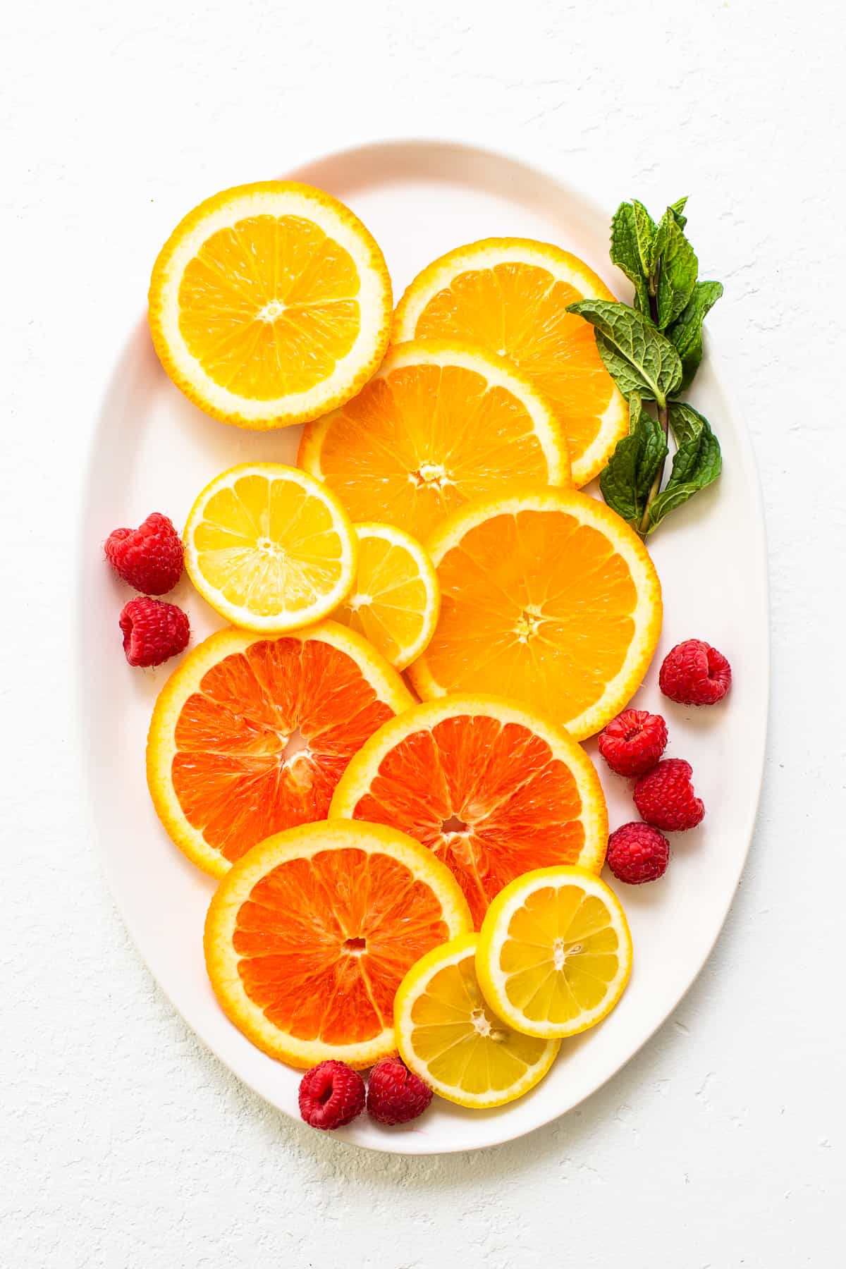 Fruit and fresh herbs on a white plate. 