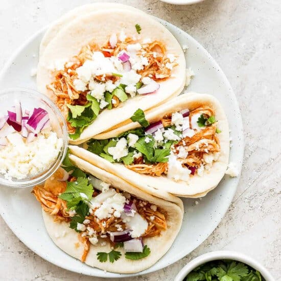 Plated chicken tinga tacos with toppings.