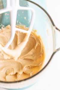 A bowl of peanut butter batter being mixed with a whisk.