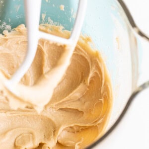 A bowl of peanut butter batter being mixed with a whisk.