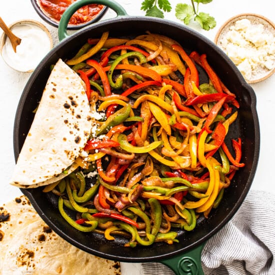 A skillet filled with peppers and tortillas.