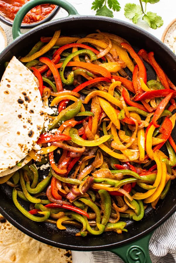 A skillet filled with peppers and tortillas.