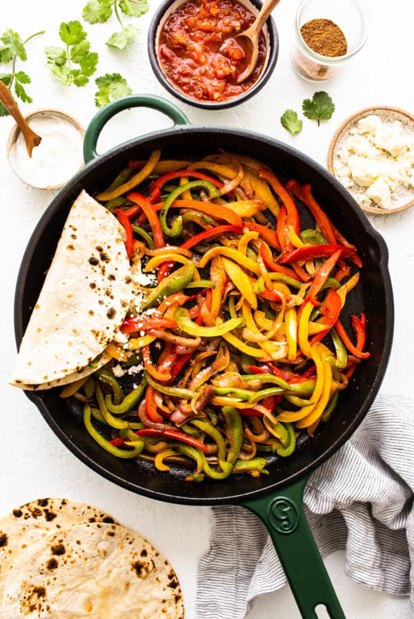 A skillet filled with peppers and tortillas.