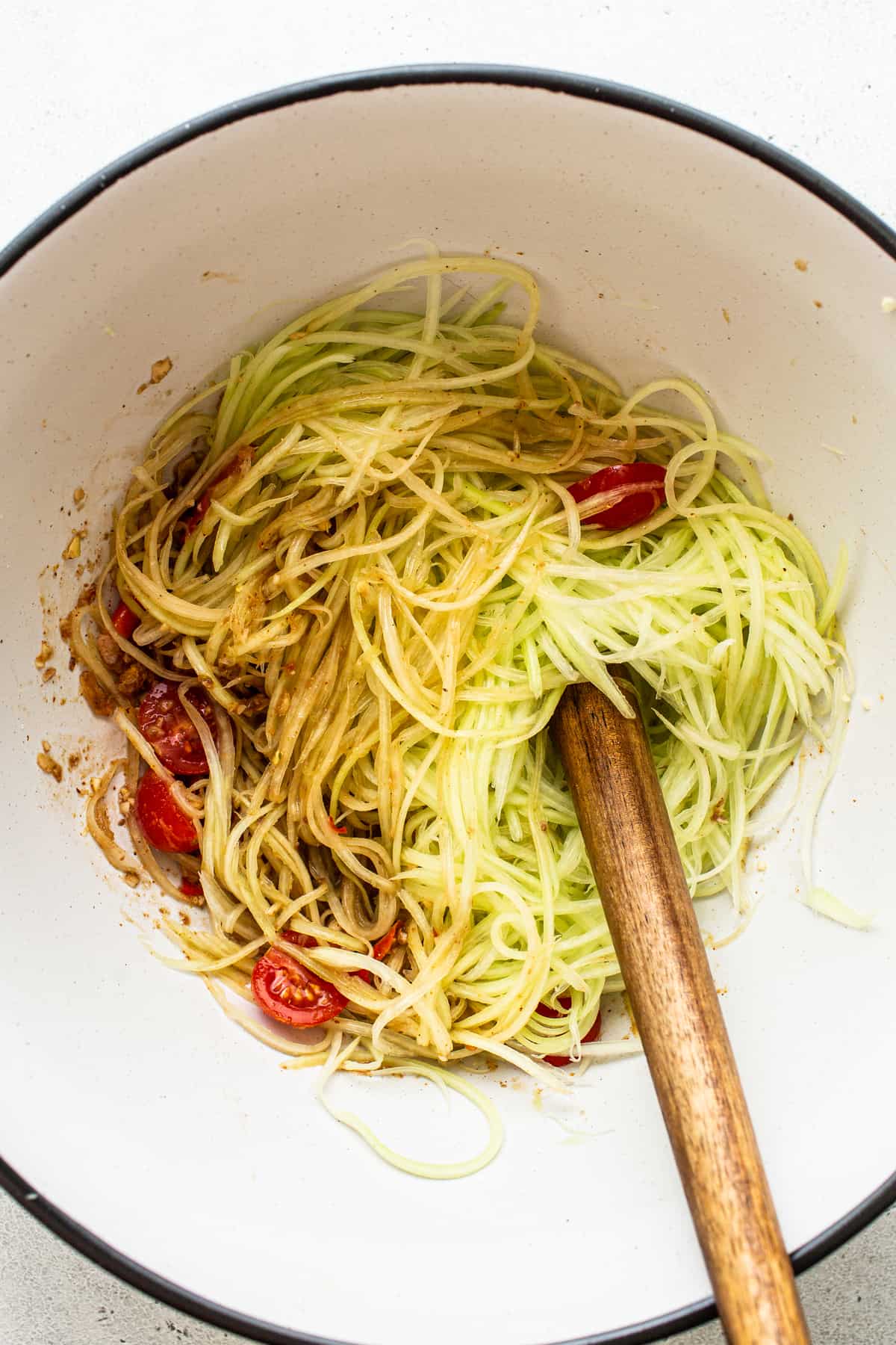 Shredded papaya and cherry tomatoes in a bowl.