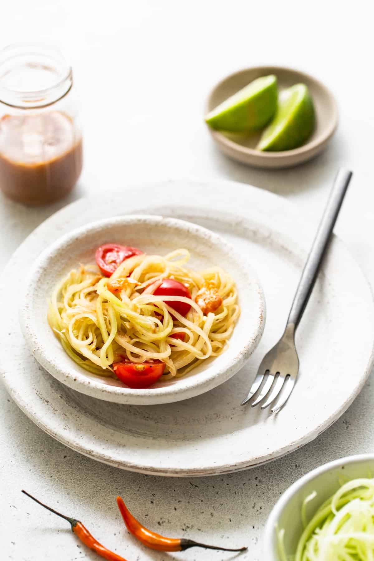 Papaya salad in a bowl with a fork.