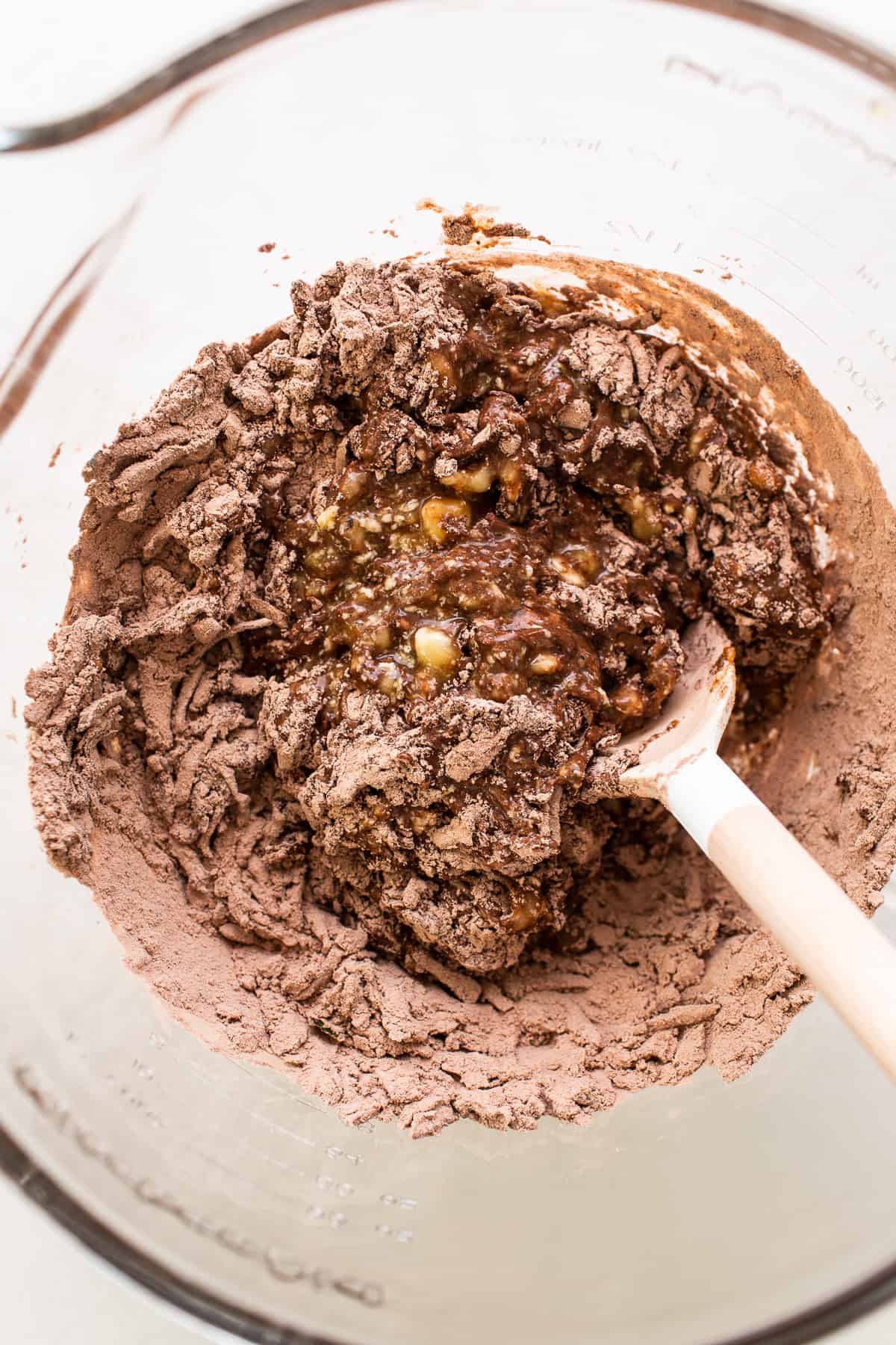 Dry and wet ingredients combined in a bowl for chocolate zucchini bread.