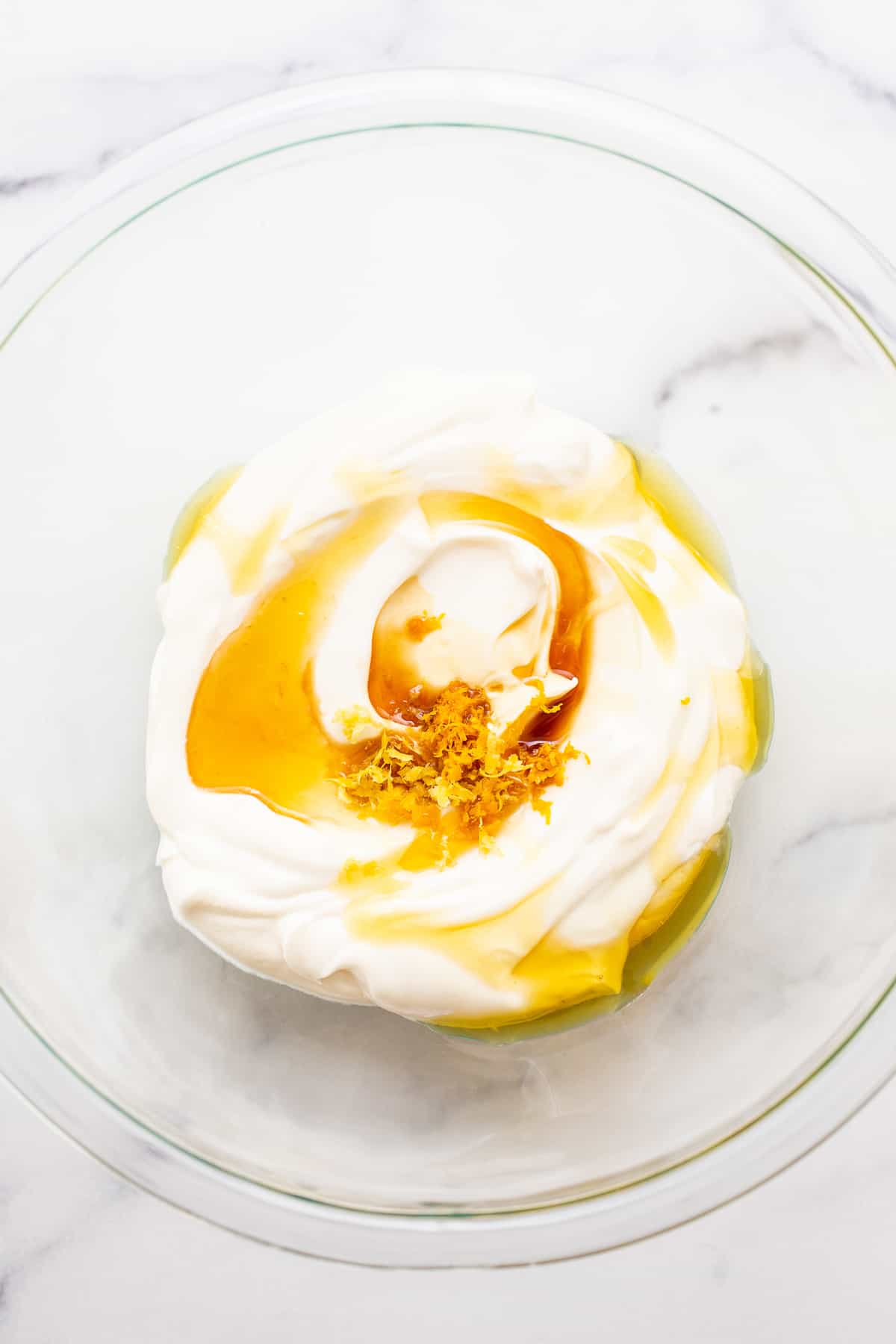 Greek yogurt with honey and lemon zest in a bowl.