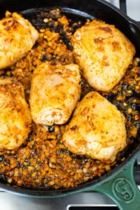 Chicken breasts in a skillet on a stove top.