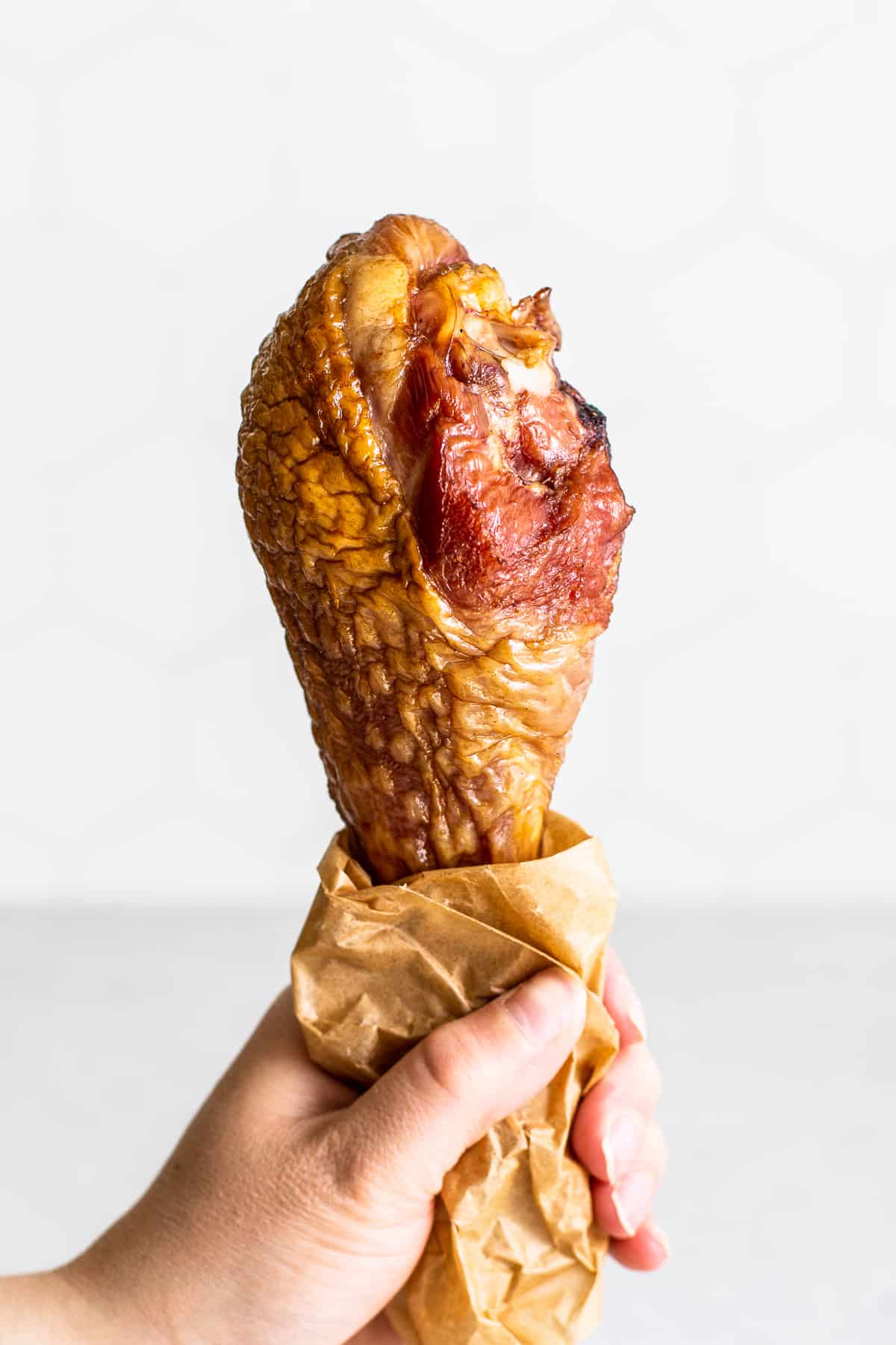 Smoked turkey leg in a hand. 