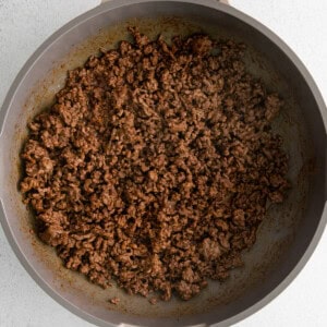 A frying pan filled with ground beef.