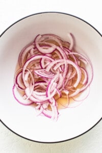 Quick pickling onions in a bowl.