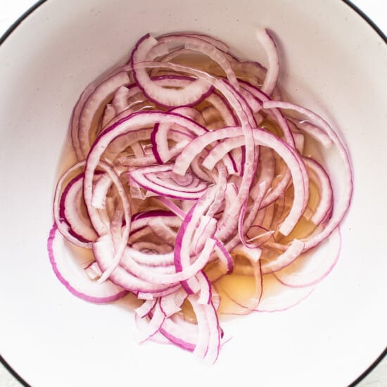 Quick pickling onions in a bowl.