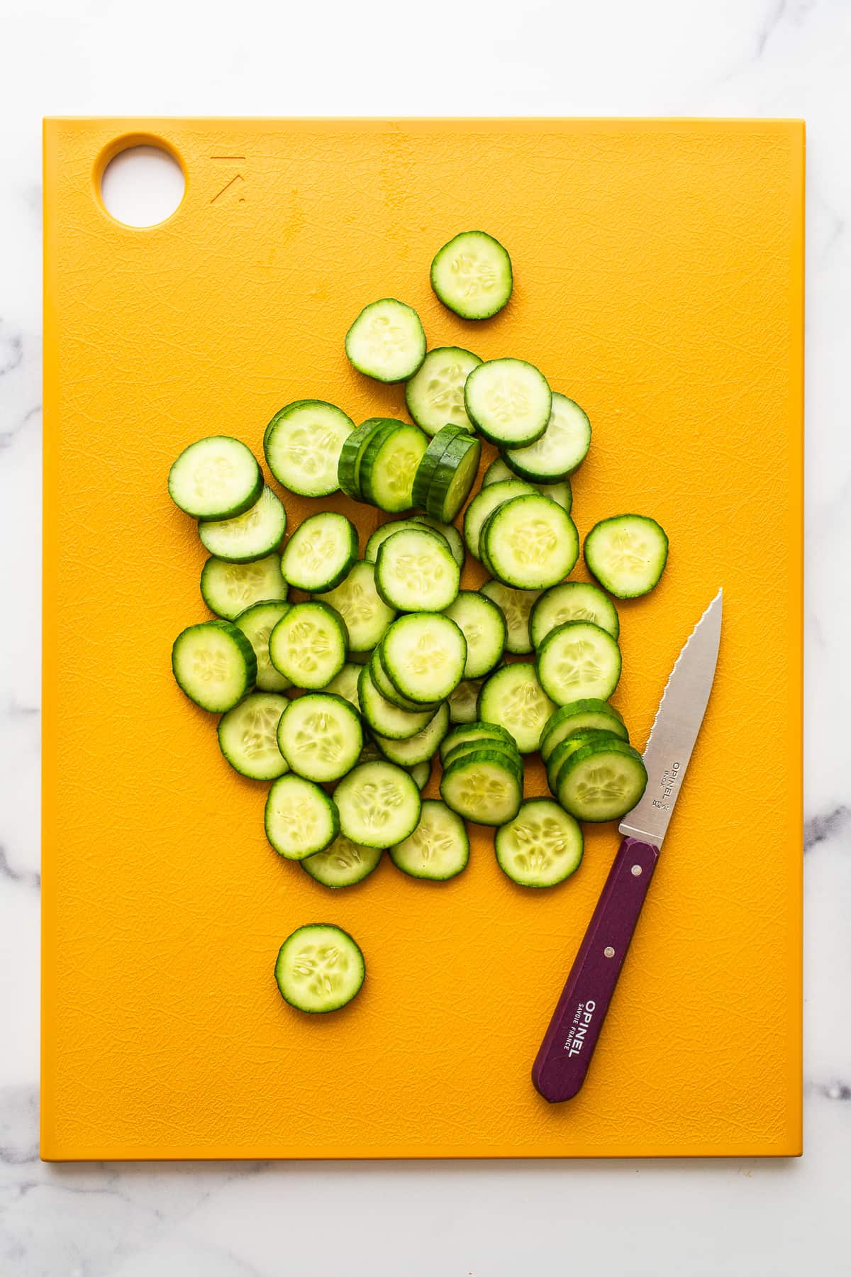sliced cucumber on cutting board.