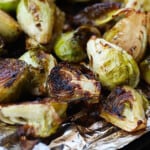 Grilled brussels sprouts cooked on aluminum foil.