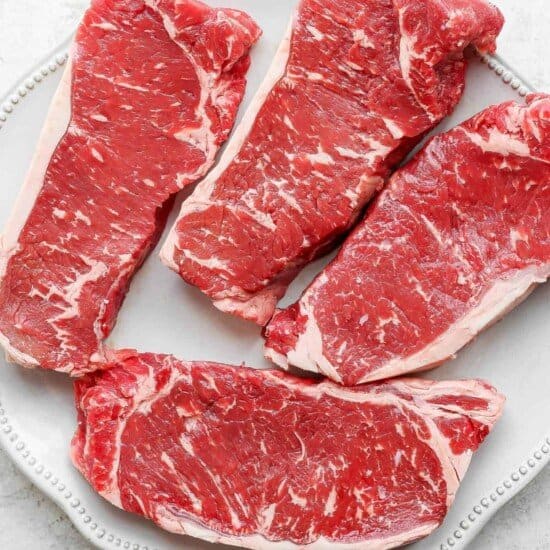 raw steak on plate.