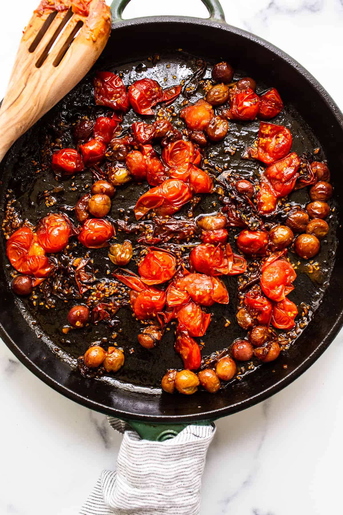 cooked down cherry tomatoes in skillet.