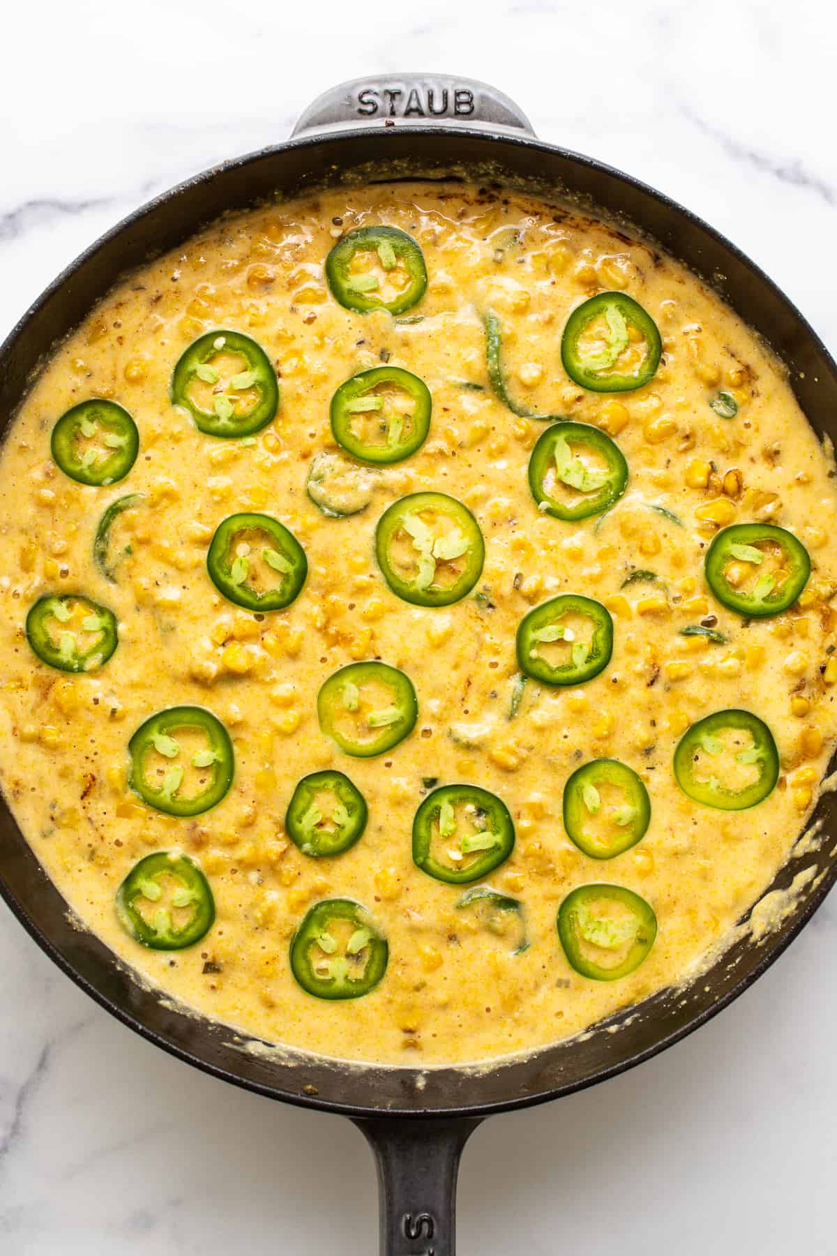 Jalapeno corn pudding in a cast iron skillet ready to be baked.