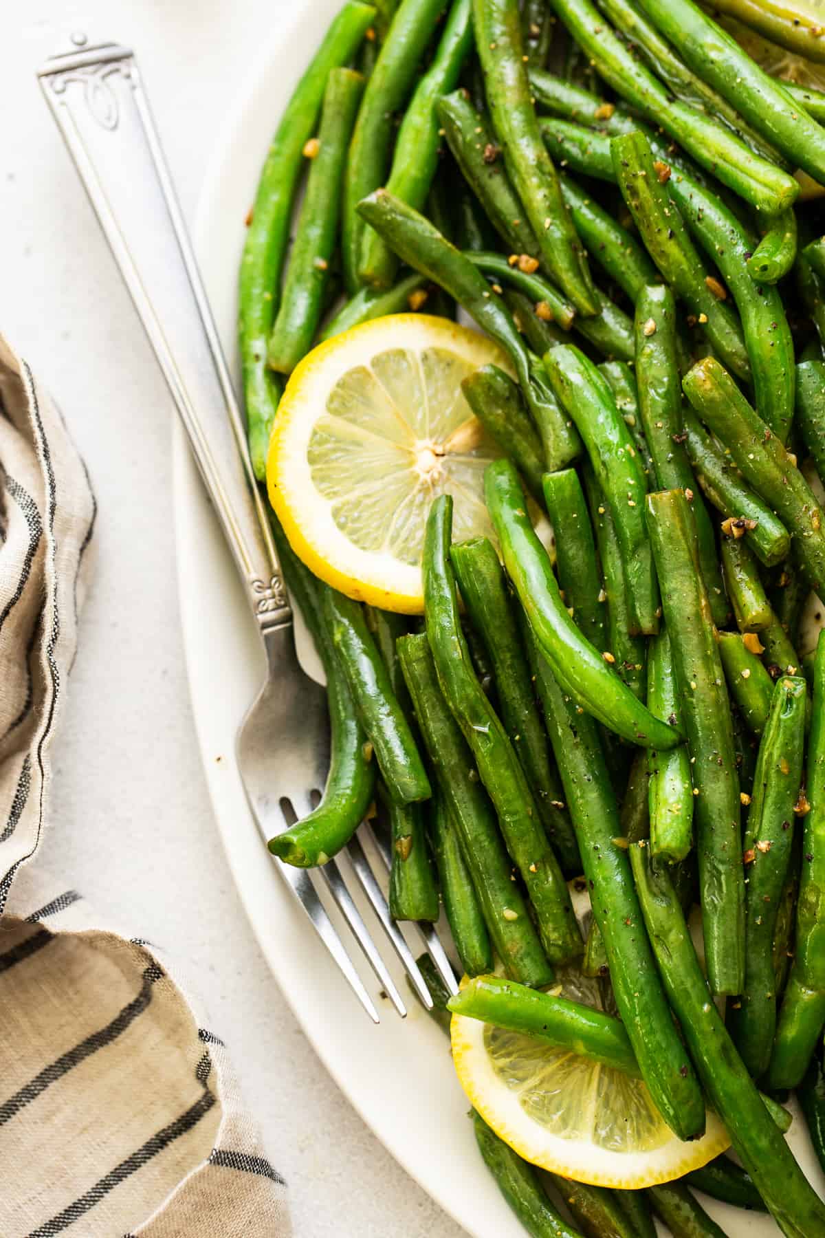 cooked green beans with lemon and garlic on platter.
