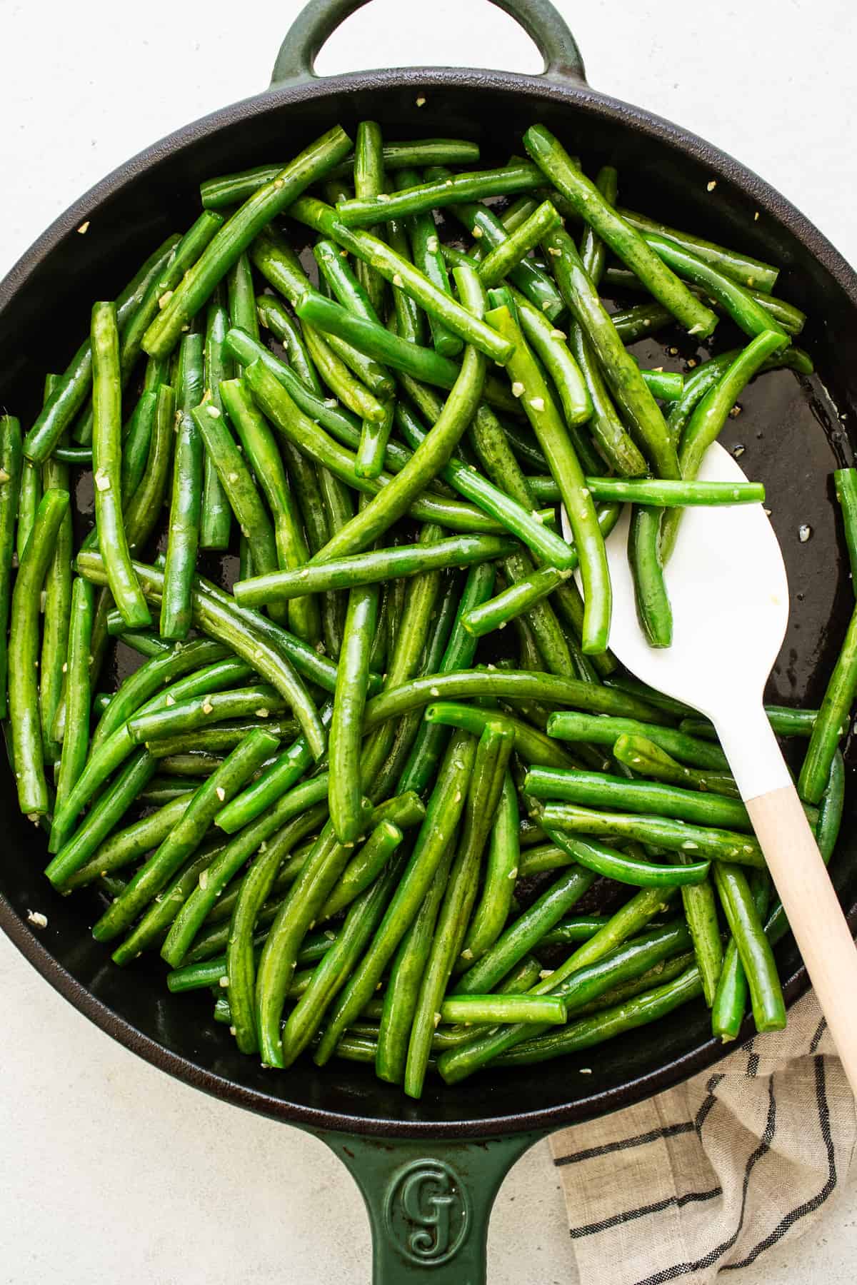 sautéing green beans with garlic in cast iron pan.