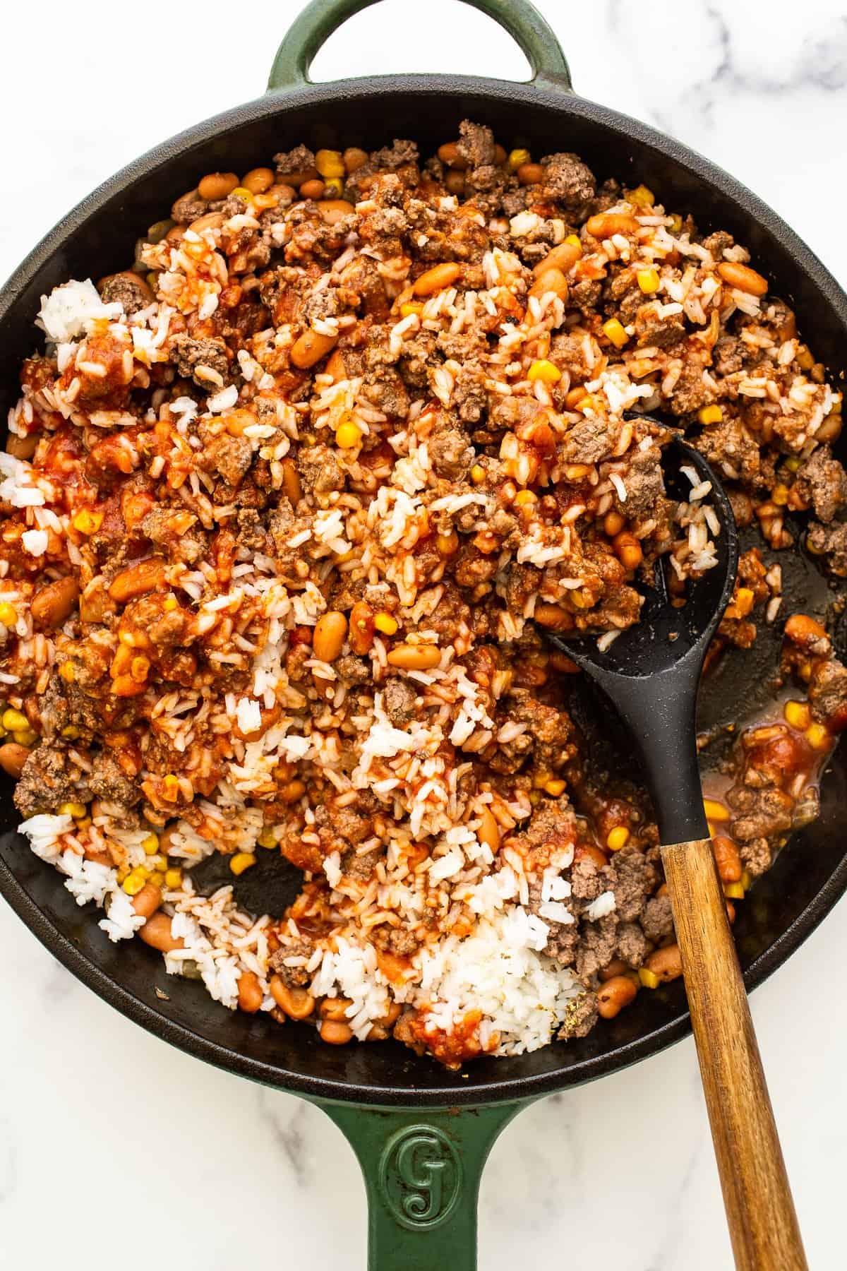 Rice, beans and ground beef in a cast iron skillet.