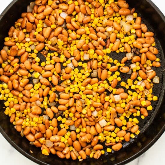 A skillet filled with beans and corn.