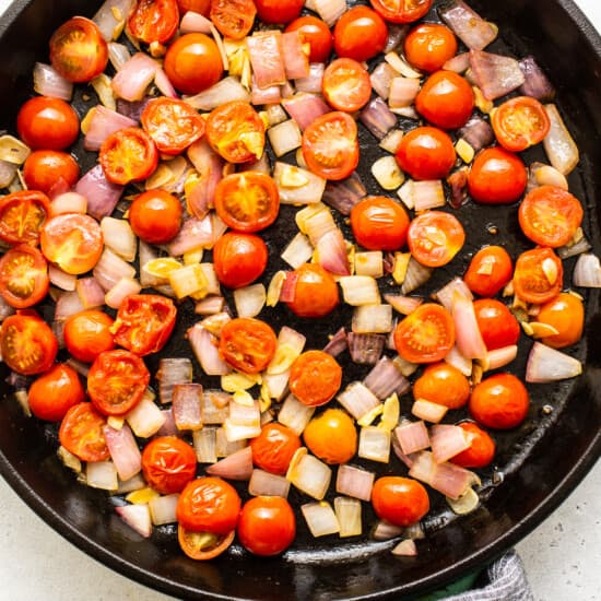 Tomatoes and onions in a skillet.