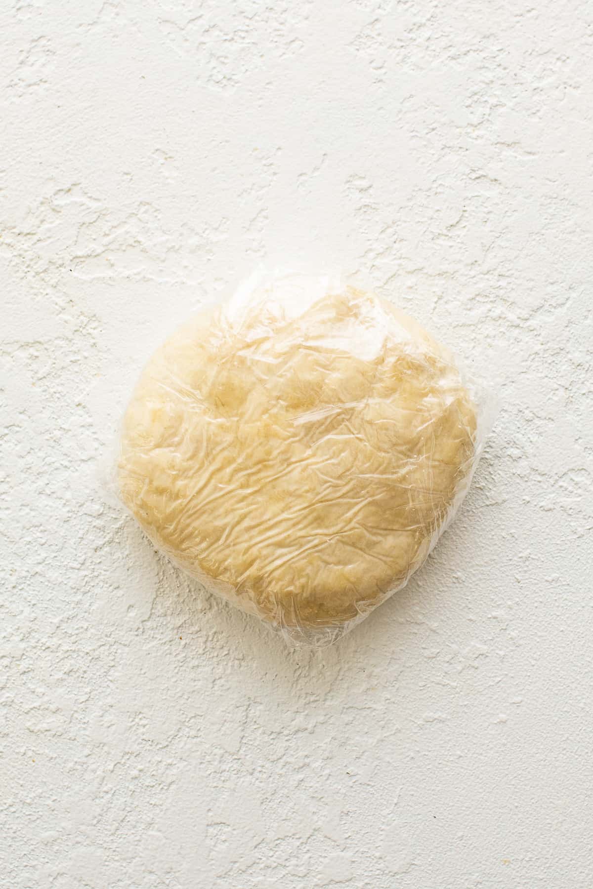 Empanada dough wrapped in plastic wrap.