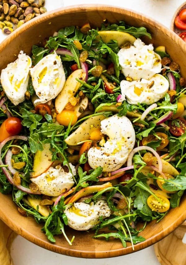 Apple burrata salad with ripped burrata on top of the salad.